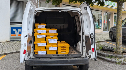 Ein Lieferwagen mit vielen gelben Großhandelskisten.