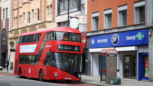 Foto: Ein roter Doppeldeckerbus vor einer Boots-Pharmacy in England.