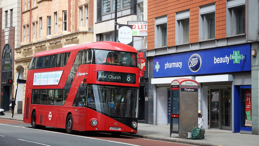 Foto: Ein roter Doppeldeckerbus vor einer Boots-Pharmacy in England.