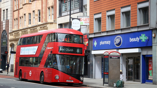 Foto: Ein roter Doppeldeckerbus vor einer Boots-Pharmacy in England.
