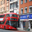 Foto: Ein roter Doppeldeckerbus vor einer Boots-Pharmacy in England.