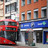 Foto: Ein roter Doppeldeckerbus vor einer Boots-Pharmacy in England.