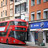 Foto: Ein roter Doppeldeckerbus vor einer Boots-Pharmacy in England.