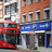 Foto: Ein roter Doppeldeckerbus vor einer Boots-Pharmacy in England.