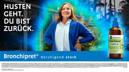 Werbeanzeige für das pflanzliche Arzneimittel „Bronchipret® Tropfen“ von Bionorica. Links steht der Slogan „Husten geht. Du bist zurück.“ in weißer Schrift auf dunklem Hintergrund. Im Zentrum ist eine Person in weißem Oberteil und blauem Cardigan zu sehen, die mit beiden Händen in die Hüften gestützt vor einer Glasfront steht. Rechts befindet sich eine große Abbildung der Produktflasche „Bronchipret® Tropfen“ mit grün-blauem Etikett. Darunter ist der Claim „Beruhigend stark“ sowie ein längerer Informationstext in kleiner Schrift. Der Hintergrund zeigt eine natürliche Szenerie mit Bäumen und Lichtreflexen.