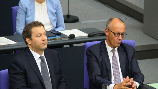 Klingbeil und Merz nebeneinander auf ihren Plätzen im Bundestag