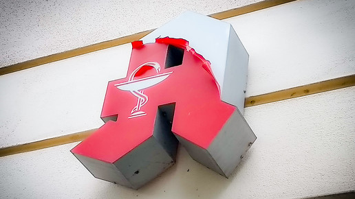 Foto: Ein Apotheken-A, bei dem die rote Farbe abblättert.