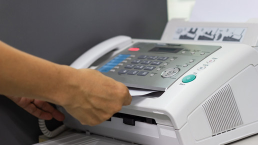 Foto: Eine Person bedient ein Faxgerät.