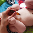 Baby bekommt Öltropfen einmassiert