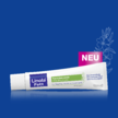 Tube Linola Fett Nachtkerzenöl Creme vor blauem Hintergrund, mit Hinweis ‚NEU‘ und stilisierter Nachtkerzenblüte.