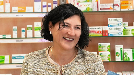 Tanja Reischl-Stenske lächelt und zeigt in ihrer Apotheke ein Produkt. Mehr dazu im Artikel.