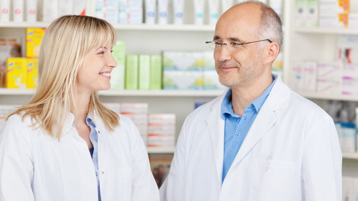 Apotheker und PTA oder Apothekerin schauen sich an