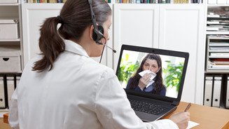 Assistierte Telemedizin: Das sind die Anforderungen Symbolbild: Eine Ärztin vor einem Laptop während einer Videosprechstunde.