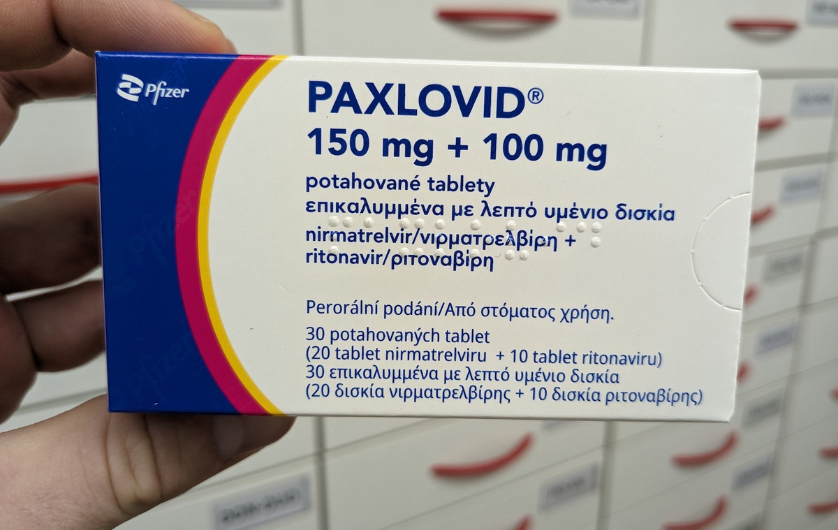Offener Umkarton Paxlovid (Pfizer) aus dem zwei Blister mit weißen ovalen Tabletten rausgucken.