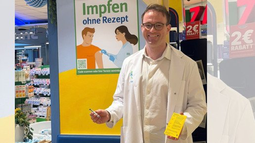 Apotheker Moritz Lauterbach mit Impfpass und Spritze.
