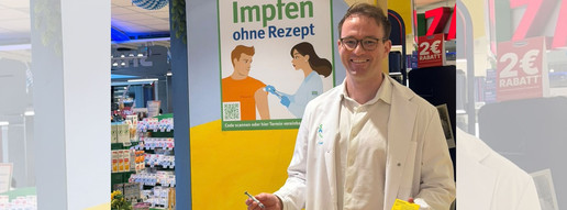Apotheker Moritz Lauterbach mit Impfpass und Spritze.