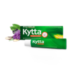 Kytta Schmerzsalbe in grüner Tube vor passender Verpackung, daneben Beinwellblüten und Wurzeln. Aufdruck: ‚Kytta Schmerzsalbe – Bei Schmerzen und Schwellungen