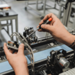 Techniker führt mit einem Schraubendreher Wartungsarbeiten an einer mechanischen Komponente eines Meditech-Apothekenautomationssystems durch.