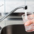 Symbolbild: Person füllt ein Glas Wasser an der Spüle 