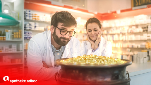 Foto: Zwei Personen in der Apotheke betrachten einen Topf voller Gold.