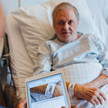 Pflegekraft scannt mit Tablet den Strichcode auf dem Armband eines Patienten