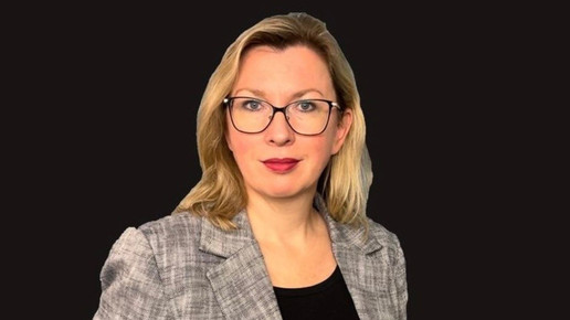 Portraitfoto von Astrid Janovsky im Blazer vor schwarzem Hintergrund