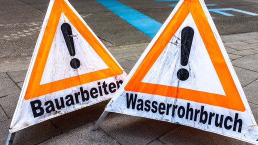 Warnschilder bei einem Wasserrohrbruch an einer Baustelle