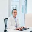 Bild von Dr. Jan-Christoph Loh, Medizinischer Direktor der Wellster Healthtech Group vor einen Computer am Schreibtisch sitzend