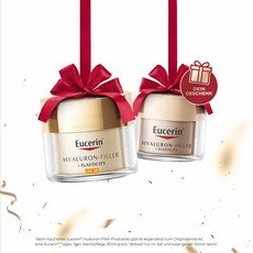 Produktaufnahme für Eucerin: Zwei goldene Cremetiegel der Hyaluron-Filler + Elasticity Serie hängen an roten Geschenkbändern.