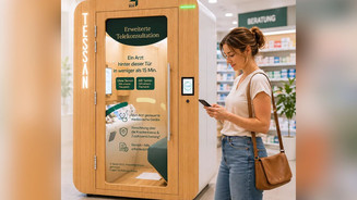 Frau am Handy steht vor der Doctorbox-Kabine in einer Apotheke