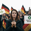 Zusehen ist eine Menschen Menge mit Deutschlandflaggen und Schildern auf denen steht "Heilen ist kein Verbrechen"