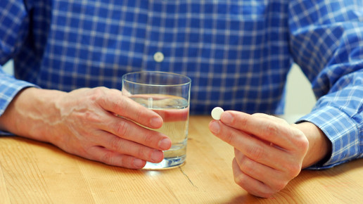 Foto: Eine männliche Person hält eine Tablette in der Hand.