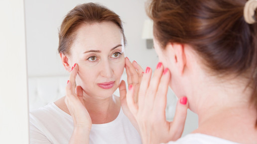 Foto: Eine weibliche Person blickt in den Spiegel.