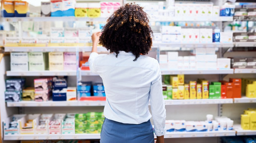 Foto: Eine Person steht vor einem Drogerieregal mit Rücken zum Betrachter