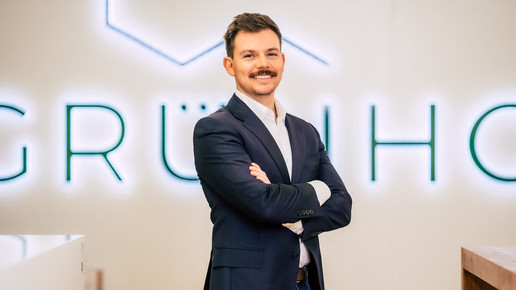 Stefan Fritsch von Grünhorn mit verschränkten Armen vor einer Firmenwand