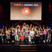 Abgebildet ist ein Foto der 2024 Vision.A Awards von allen Award Gewinner:innen gemeinsam auf der Bühne.