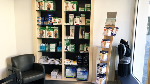 Regal mit verschiedenen Hilfsmitteln wie Bandagen und Einstiegshilfen.