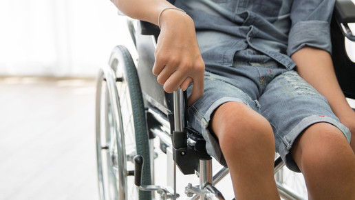 Symbolbild, ein an Kinderlähmung erkranktes Kind im Rollstuhl