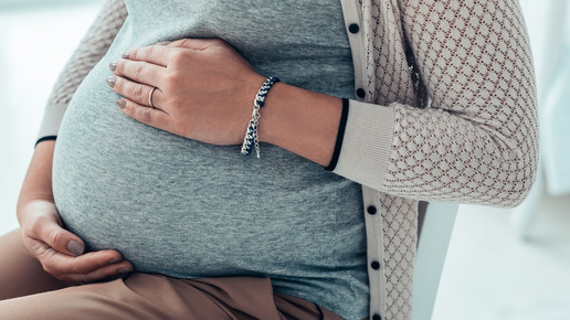 Foto: Eine schwangere Frau hält ihren Bauch