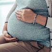 Foto: Eine schwangere Frau hält ihren Bauch