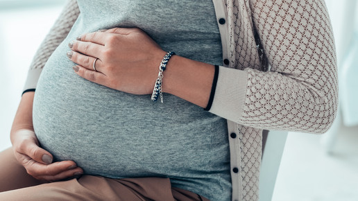 Foto: Eine schwangere Frau hält ihren Bauch