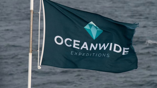 Flagge der Reederei Oceanwide Expeditions an einem Schiff