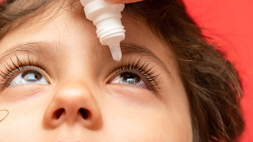Augentropfen werden einem Kind appliziert.