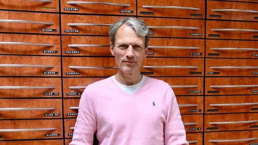 Apotheker Andreas Binninger vor einem Generalalphabet.