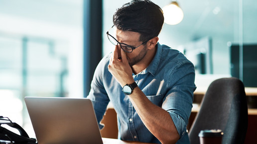 Foto: Ein Mann sitzt vor einem Laptop in einer Büroumgebung.