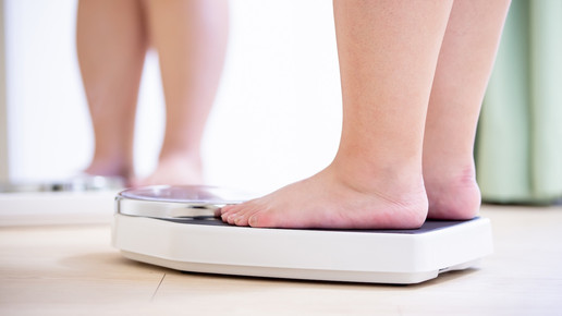 Foto: Eine adipöse Person steht auf einer Waage