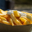Portion Pommes mit Majo oben drauf in einer kleinen Pappschale