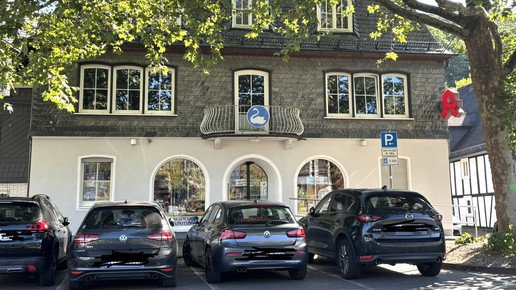 Die Schwanen-Apotheke von außen mit Blick auf die Front und parkende Autos.