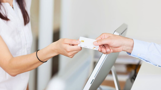 Foto: Eine Person in weißem Oberteil nimmt eine elektronische Gesundheitskarte (eGK) entgegen.