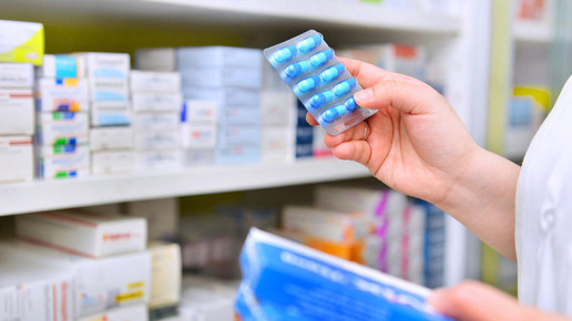 Symbolbild: Apotheker hält ein Medikament in der Hand. 